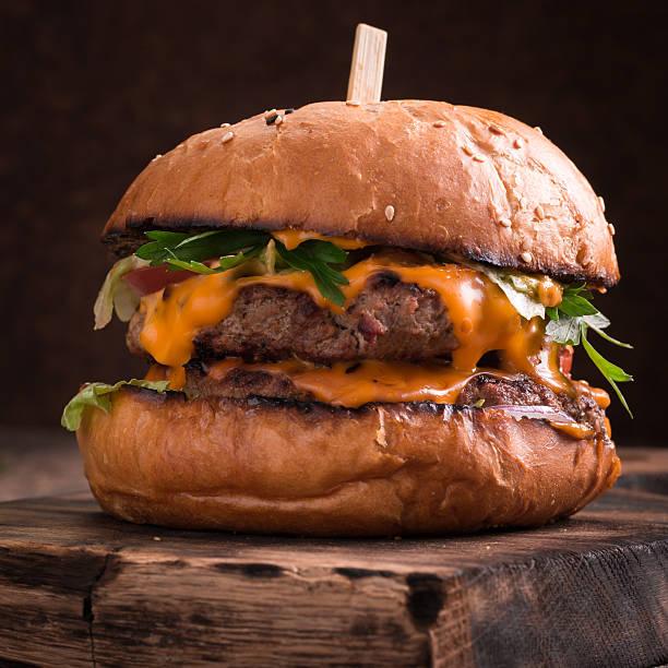 istock Tasty grilled burger with lettuce and mayonnaise , rustic wooden table 600683864