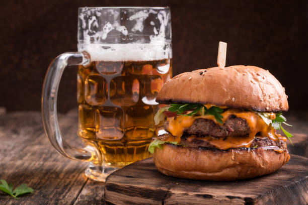 istock Fresh hamburger with a beer on a wooden table. 600684160