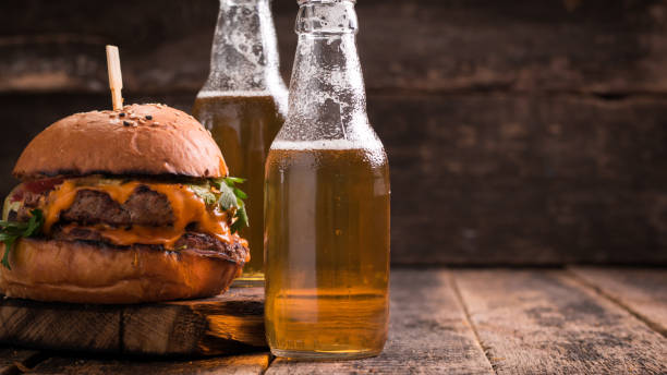 istock Fresh hamburger with a beer on a wooden table. 600684614