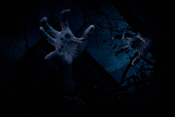 istock Zombie hand rising out from old castle over cloudy sky 600686060