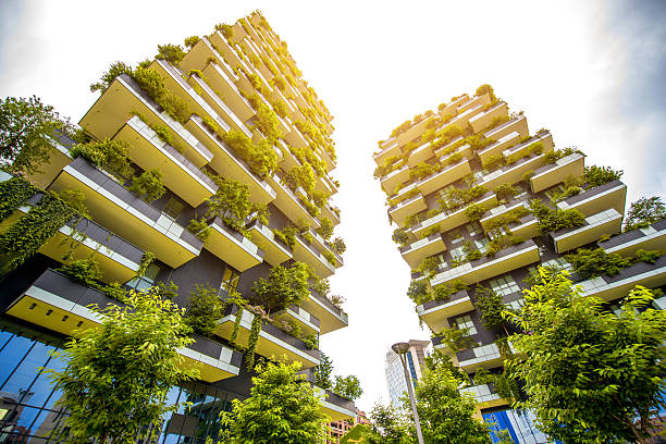 Modern residantial district in Milan Milan, Italy - June 05, 2016: Pair of residential towers with trees called Bosco Verticale in the Porta Nuova district designed by Boeri Studio green skyscraper stock pictures, royalty-free photos & images