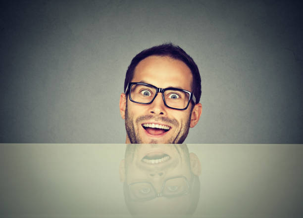 istock surprised business man hiding under the table 600689192