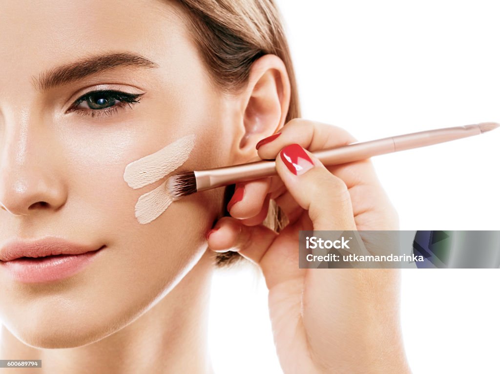 Perfect makeup. Skin tone cream lines on woman face. Skin tone cream lines on woman face. Beautiful woman portrait beauty skin healthy and perfect makeup. Studio shot. Isolated on white. Make-Up Stock Photo