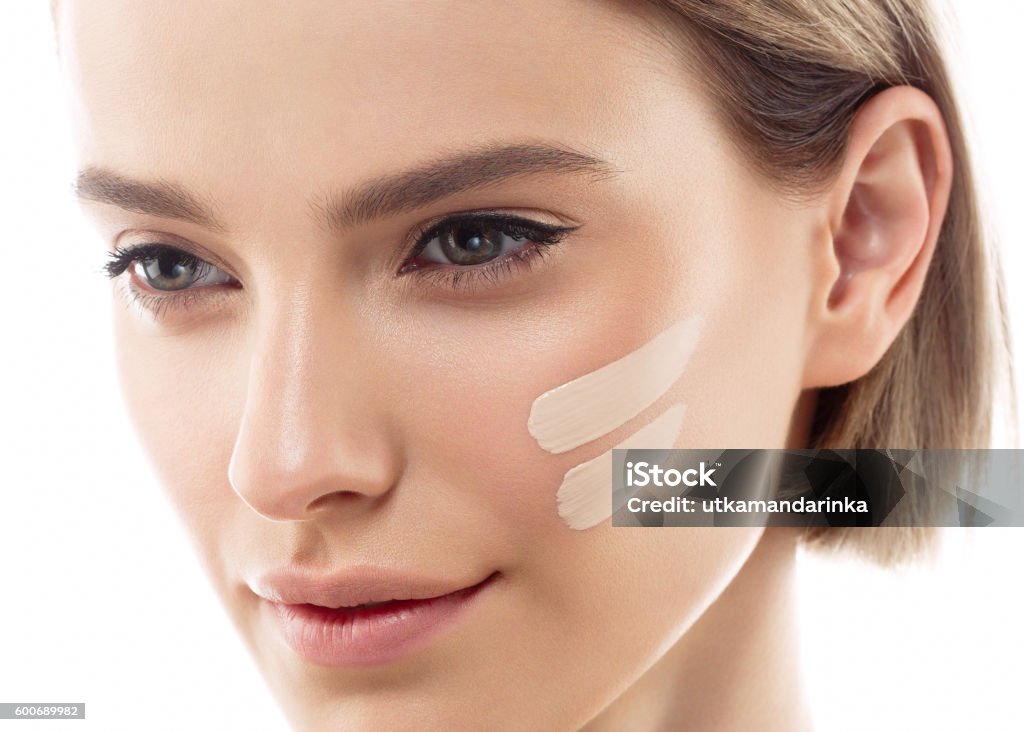 Perfect makeup. Skin tone cream lines on woman face. Skin tone cream lines on woman face. Beautiful woman portrait beauty skin healthy and perfect makeup. Studio shot. Isolated on white. Women Stock Photo