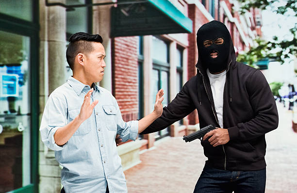istock Thief in action with gun outdoors 600691938