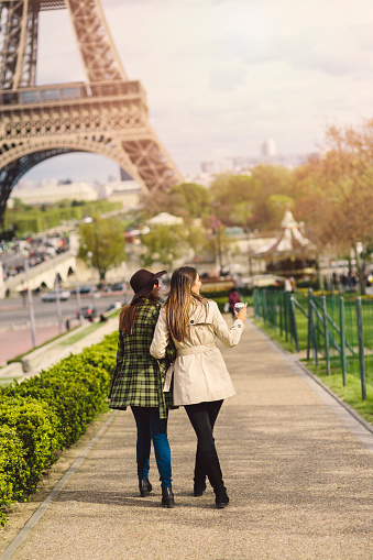 Two friends taking a walk around the Eiffel Tower in Paris.