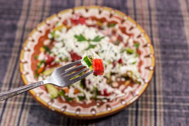 Closeup shot of a traditional bulgarian salad called Shopska prick with a fork.