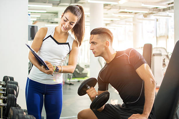 istock Female personal trainer showing exercise results to male client. 600696628