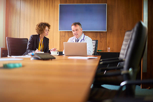 istock senior doctor with salesperson 600698078
