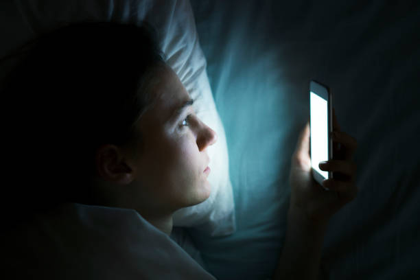 istock Woman using phone in bed at night 600702138