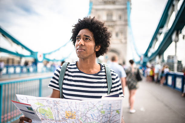 solo traveler in tower bridge area reading a map solo traveler in tower bridge area reading a map lost stock pictures, royalty-free photos & images