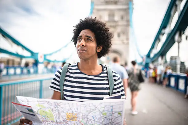 solo traveler in tower bridge area reading a map