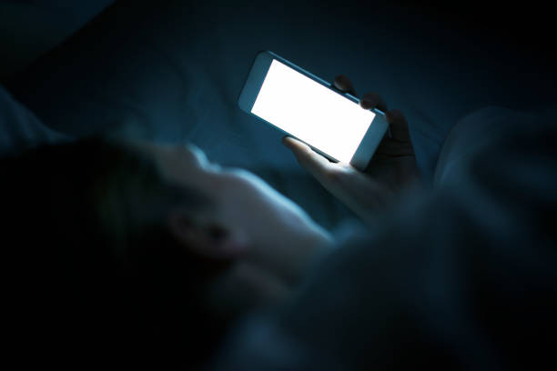 istock Woman using phone in bed at night 600990364