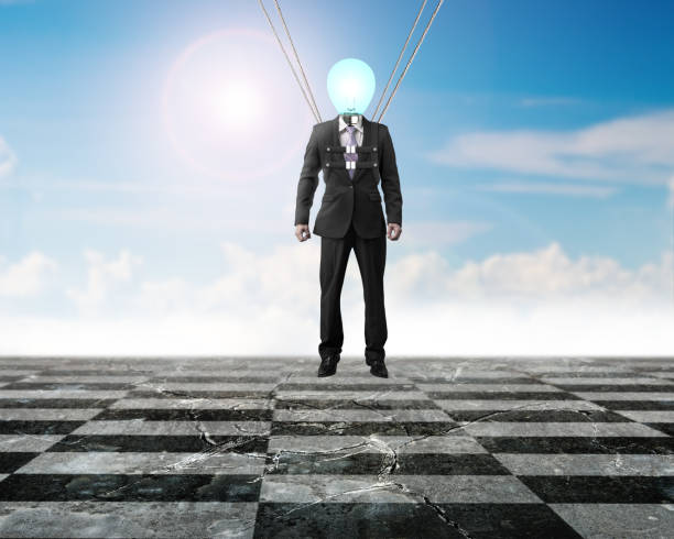 istock Businessman of light bulb head landing on chessboard ground 600991852