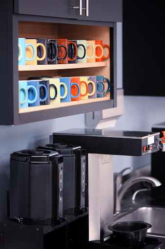 Shot of colorful mugs and a coffee station.