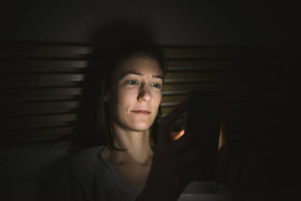 istock Woman using phone in bed at night 600995422