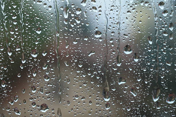 istock Rain drops on window with house and church in background 601001514