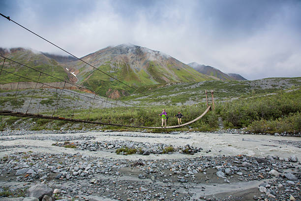 istock Backpackers hiking on a Suspension Bridge across River in Alaska 601002542