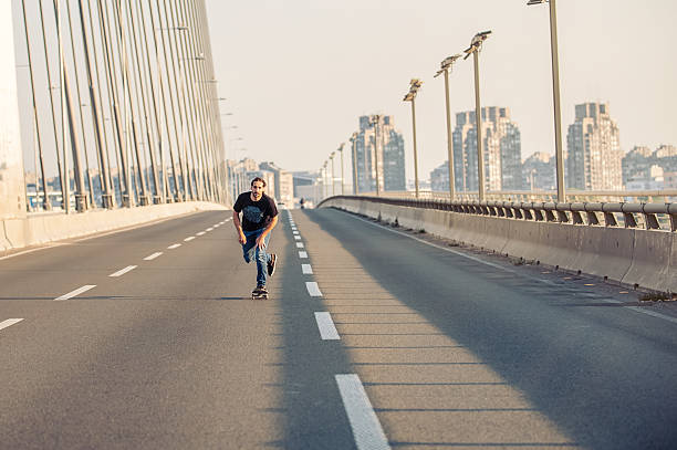 istock Skateboarder riding a skate over a city road bridge 601003774
