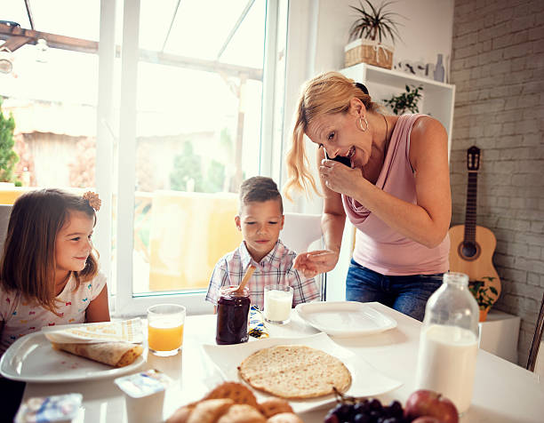 istock Busy Mother Organizing Children At Breakfast In Kitchen 601003976