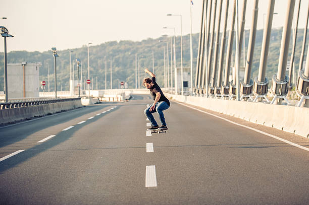 istock Skateboarder doing jumps on the city road bridge 601004010