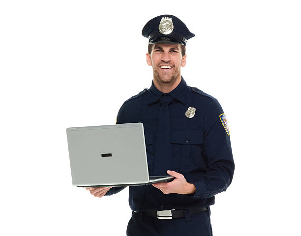istock Smiling police working on laptop 601005728