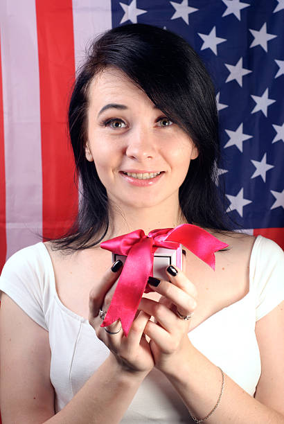 istock young attractive woman with gift in hand, 601008596