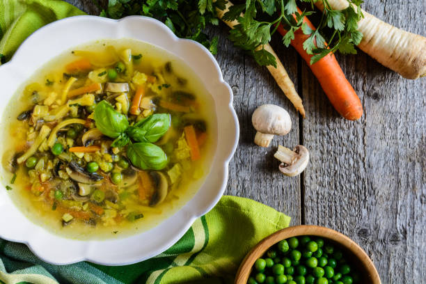 istock Mushroom soup with carrot, pea, kale, parsley, celery and onion 601009300