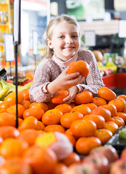 istock Little girl selecting ripe tangerines 601013196