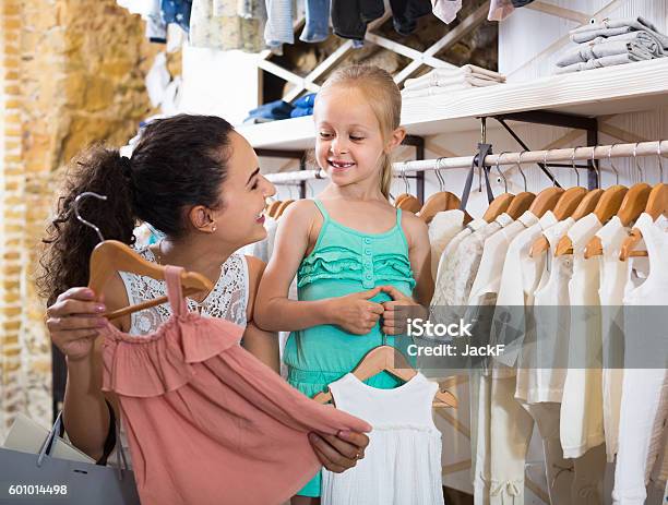 Mujer Joven Con Niña Pequeña En Boutique De Ropa Para Niños Foto de stock y  más banco de imágenes de Madre - iStock