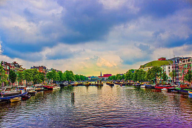Amsterdam is the capital and most populous municipality of the Kingdom of the Netherlands. Amsterdam has a population of 841,186. The city is located in the province of North Holland in the west of the country. Amsterdam's name derives from Amstelredamme, indicative of the city's origin as a dam of the river Amstel. Horizontal composition. Image developed from RAW format.
