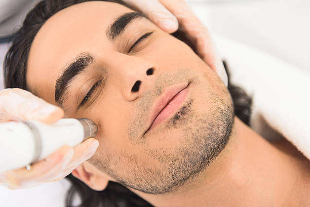 istock Young man enjoying cavitation facial peeling 601014550