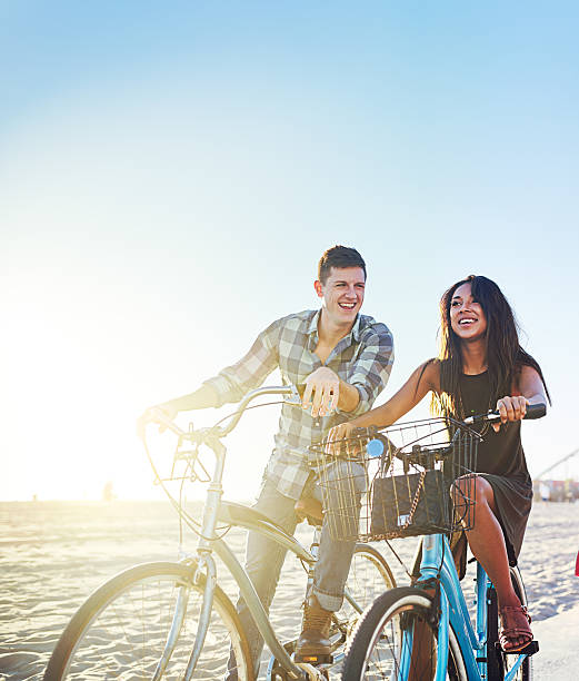 istock couple on bicycles stopped at sunny california beach 601015922