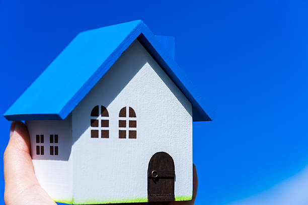 istock Home image, blue house toy in hands 601019416