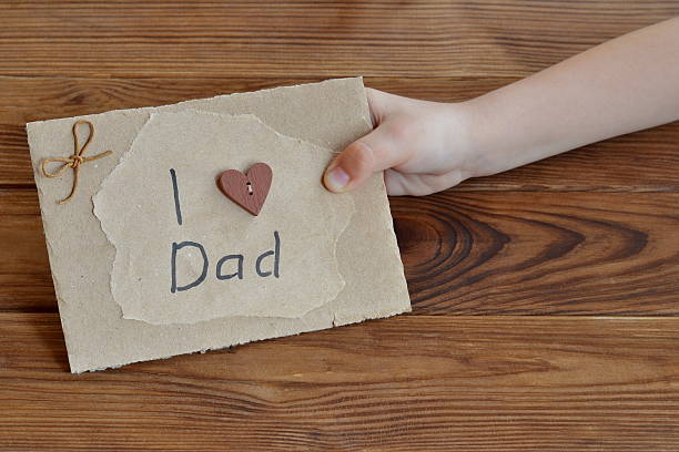 istock Child holds a card with a message I love dad 601026148