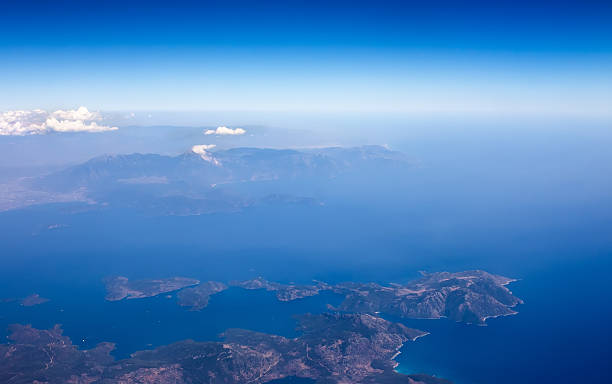 paysage de la fenêtre de l’avion, montrer la terre, la mer et les nuages. - horizon over water white green blue photos et images de collection