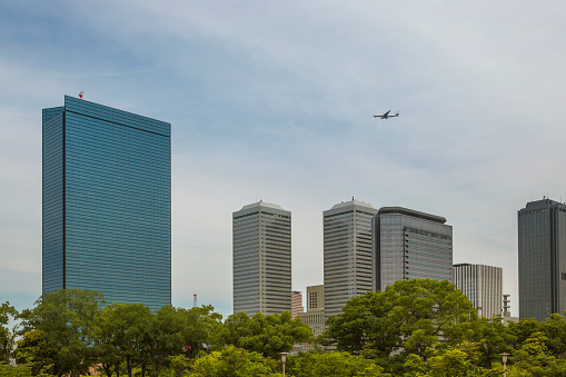 Modern Highrise buildings and a passenger plane at citycenter of osaka japan