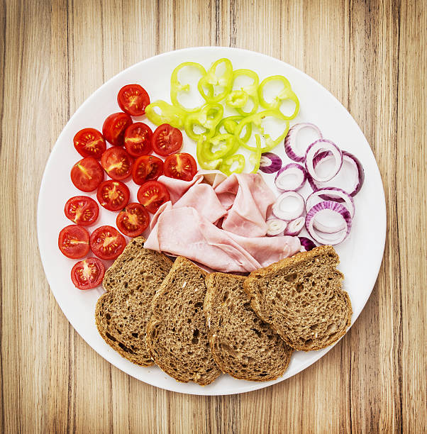 istock Whole wheat bread with ham, onion, paprika and cherry tomatoes 601032716