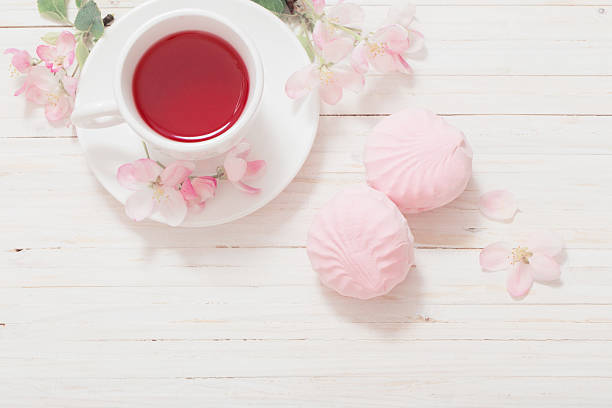 istock Red tea with flowers on white wooden background 601033748