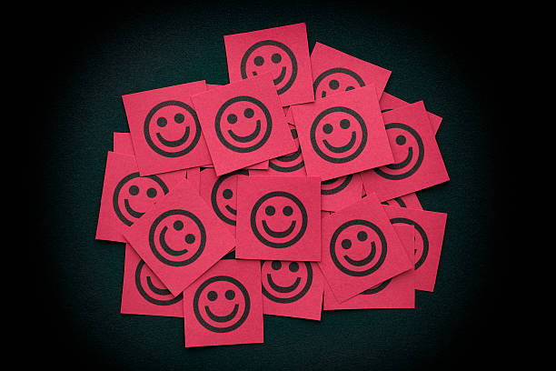 Red paper notes with happy faces Red paper notes with happy faces. Close up. smiley face postit stock pictures, royalty-free photos & images