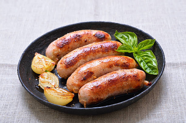 Grilled sausages in frying pan stock photo