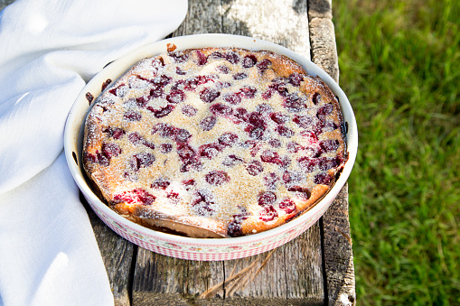 Cherry clafoutis. Homemade cherry pie on rustic background.