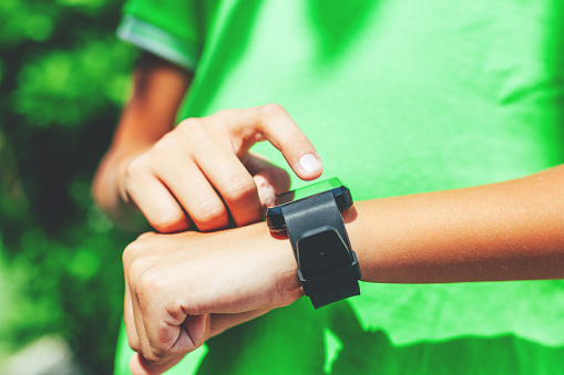 Boy touching smartwatch on the move