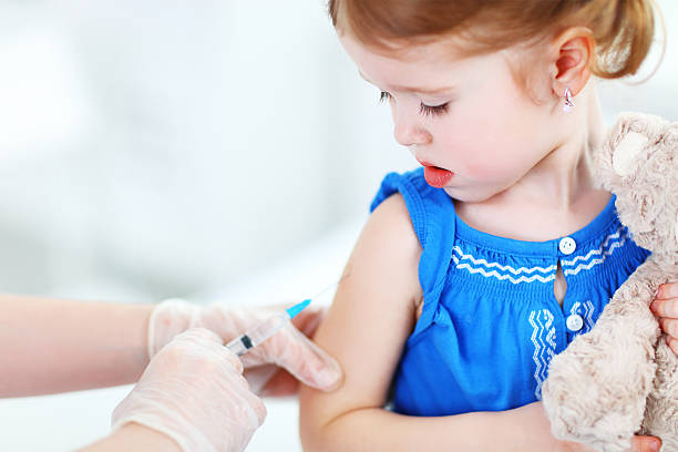 istock Doctor holds an injection vaccination child 601119218