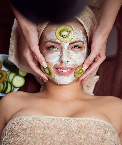 Treatment with kiwi mask on facial skin Treatment with kiwi mask on facial skin, beautiful girl in spa salon women facial mask mud cucumber stock pictures, royalty-free photos & images