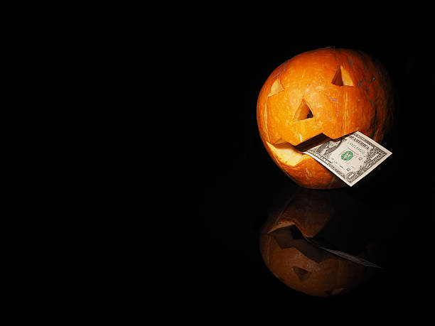 istock Halloween pumpkin with dollar on the black background 601125030