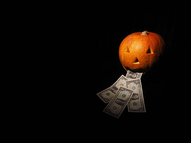 istock Halloween pumpkin with dollar on the black background 601125118