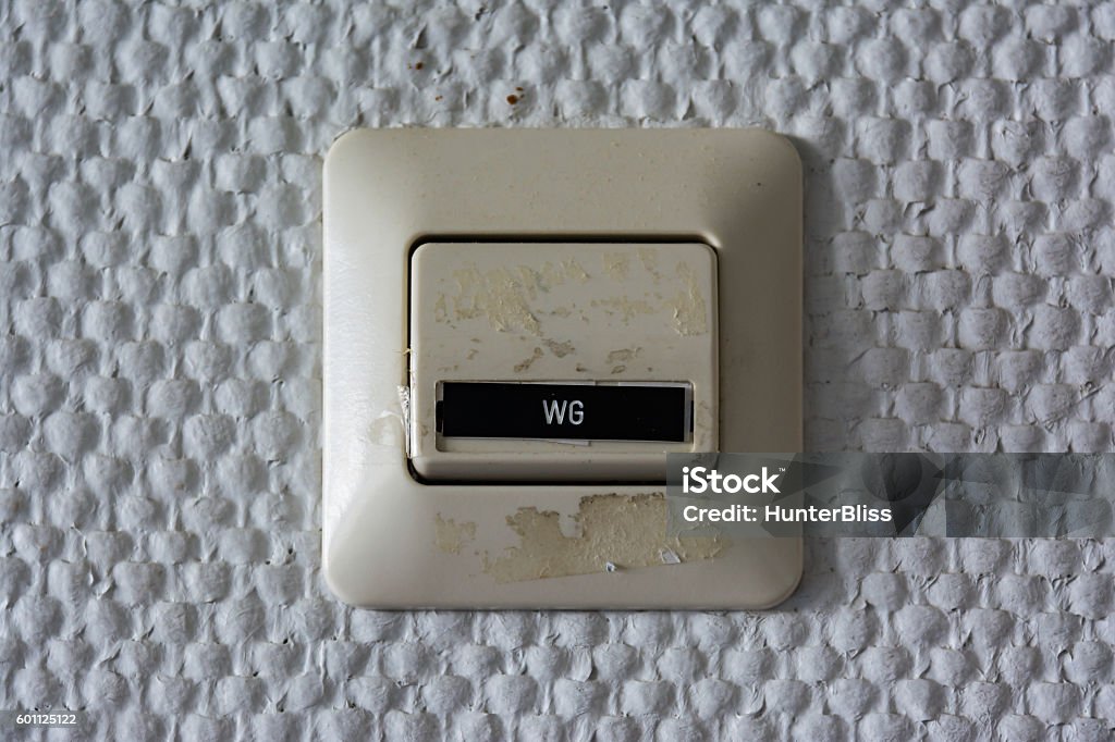 WG Wohngemeinschaft Label Switch Wall Plastic Closeup Detail Texture Architectural WG Label Switch Wall Plastic Closeup Detail Texture Architectural Apartment Clock Stock Photo