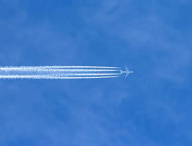 Airplane with contrails in a clear blue sky, Cruising altitude