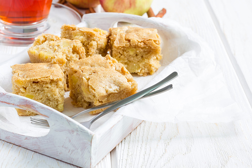 Homemade blondie (blonde) brownies apple cake, square slices in wooden tray, horizontal, copy space